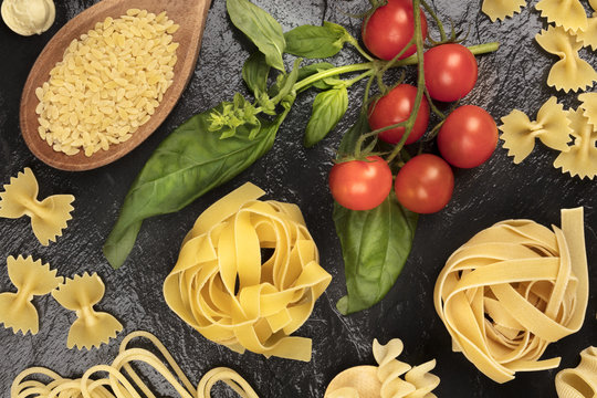 Overhead photo of different types of pasta on black