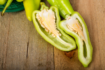 Green peppers in a basket on a wooden floor
