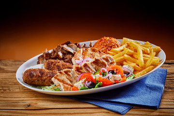 Plate full of Greek cuisine souvlaki with fries