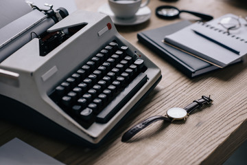 close-up shot of writer workplace with typewriter and watch
