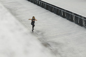 Woman running outdoors in the city, urban style, top view of fitness girl running