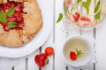Strawberry galette and herb tea. Homemade healthy wholegrain berry open pie. Fruit tart. Top view.