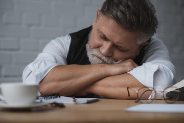 Obraz premium overworked senior writer sleeping at workplace