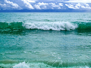 Stormy day on sea beach.
Bright turquoise ocean waves with dark blue cloudy sky in a shore of Miami beach, FL, USA.