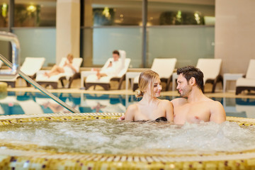 Couple in bathing suits in the pool resting spa center.