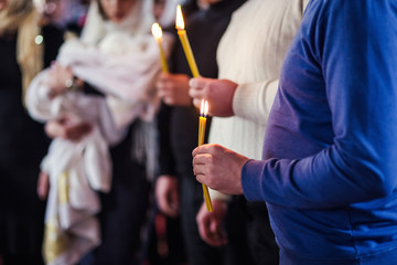 Obraz na płótnie Canvas mans hand holding a candles in church