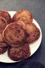 cinnamon cookies on white plate on black ceramic background