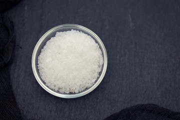 salt in small bowl on black ceramic background