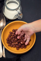 chocolate flakes in bowl with boys hand