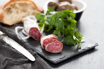 Traditional Spanish sausage Fuet on black ceramic background