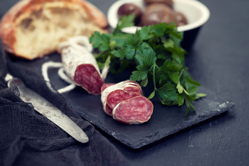Traditional Spanish sausage Fuet on black ceramic background