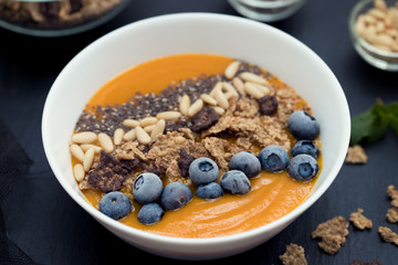 puree of mango with granola, chia and berries in white bowl