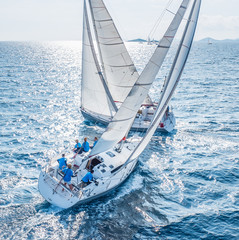 Sailing boats from bird view crossing open sea