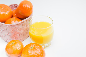 Oranges in basket and a glass of orange juice on white background, Isolated.