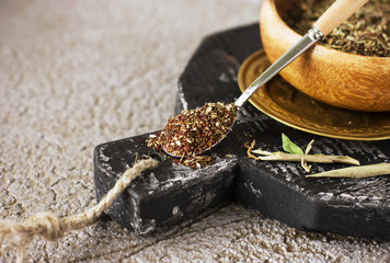 Dry spices in spoon on wooden board on the gray background