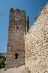 Stone tower of an ancient fortress with adjoining rocky walls