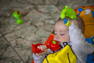 Little boy with red and green toys in his hands