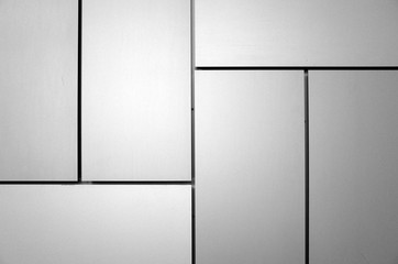 Abstract background created by rectangular panels and lines on the outside of a building. Processed in black and white for effect