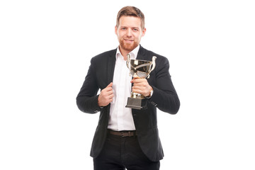 Portrait of confident young businessman wearing holding trophy on white background