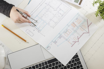 Architects working on blueprint, real estate project. Architect workplace - architectural project, blueprints, ruler, calculator, laptop and divider compass. Construction concept. Engineering tools.