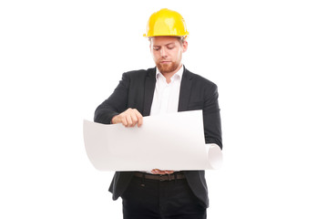 Portrait of architect wearing suit and yellow hardhat holding project plan on white background