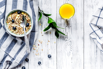 Breakfast concept with flowers on wooden background top view