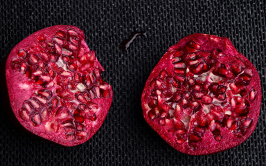 Open fresh red pomegranate on a black background