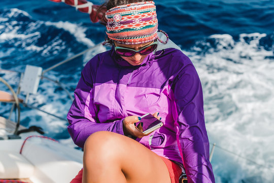 Young woman looking at smartphone aboard yacht, Croatia