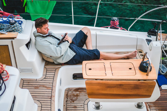 Man relaxing aboard yacht looking at digital tablet, Croatia