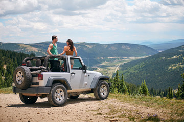 Road trip couple in four wheel convertible in Rocky mountains, Breckenridge, Colorado, USA