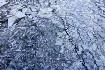 Broken ice on the surface of the river in winter. Ice floes texture