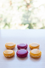 six different-colored round French macaron cookies on the table