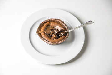 Fototapeta premium Schokoladenkuchen mit heißem Schokoladenkern - Dessert auf Teller mit Löffel, Vogelperspektive