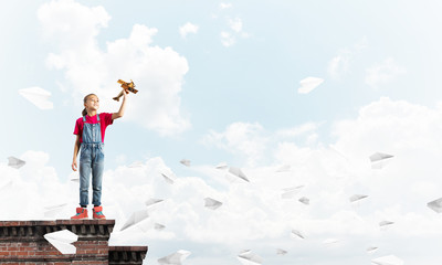 Concept of careless happy childhood with girl dreaming to become pilot
