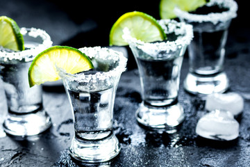 Alcohol shots with lime and salt on black background