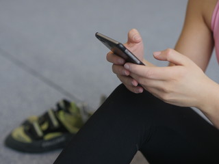 Crop sportswoman using phone