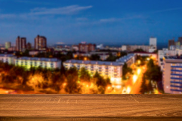 Empty wooden table with blurred background of night city. Can be used for display or montage products