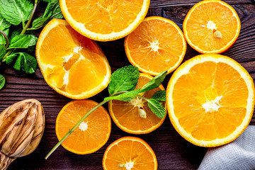 orange juice with mint squeezing on wooden kitchen background to