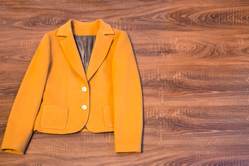 Stylish female blazer on wooden background