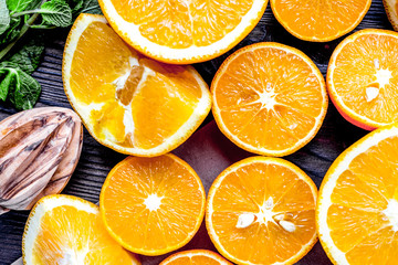 Orange juice making from fruit and mint on kitchen table top vie