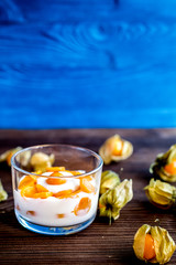 yogurt with physalis on wooden background