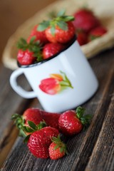 Fresh juicy strawberry in a beautiful mug on the table 