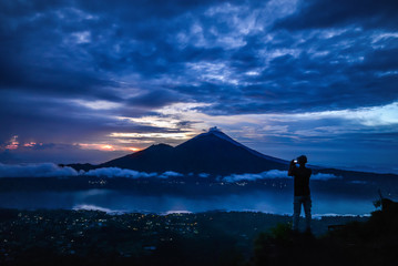 Man tacking picture of Agung volcano