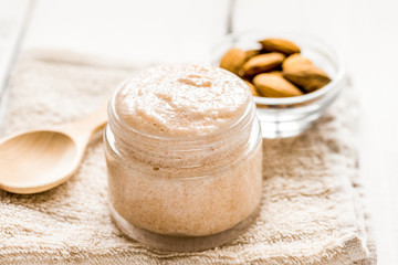 cosmetic set with almond scrub on table background
