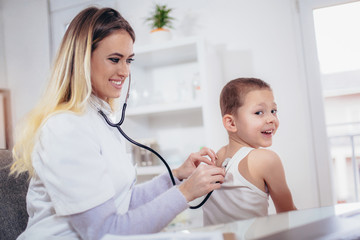 Doctor examining a little boyl by stethoscope, medicine, healthcare, pediatry and people concept