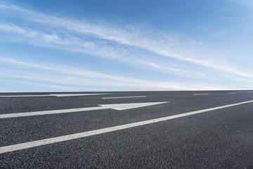 Asphalt pavements and square floor tiles under the blue sky and white clouds