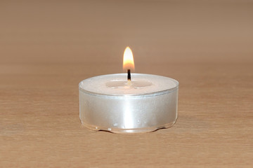 Fototapeta na wymiar Burning candle on the table