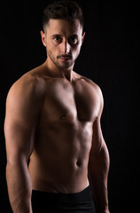 Fototapeta na wymiar Fitness session in madrid's photographic studio with a boy without a shirt