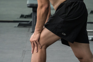 Attractive young man stretching in the gym  before training