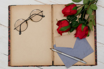 concept romantic, old notebook, roses and glasses